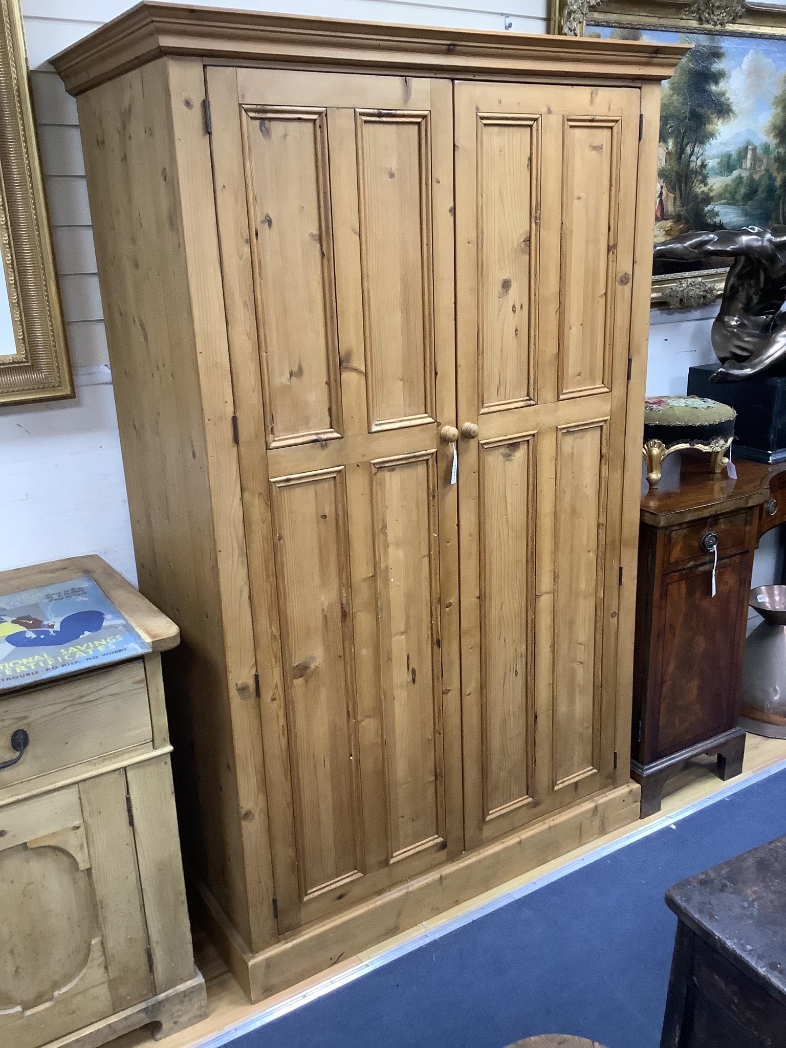 A panelled pine two door wardrobe, length 124cm, depth 59cm, height 197cm
